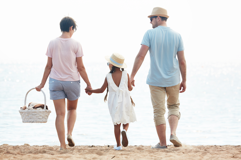 a family of three going to a picnic in the beach